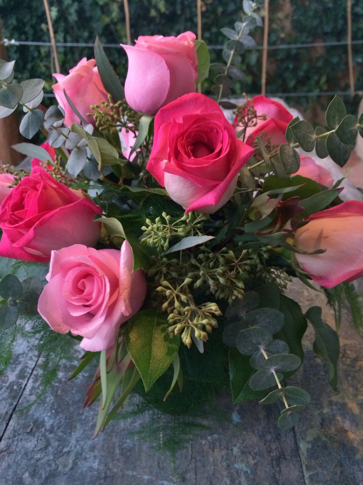 One Dozen Roses and greens with accents in a clear glass cube One Dozen Roses and greens with accents in a clear glass cube