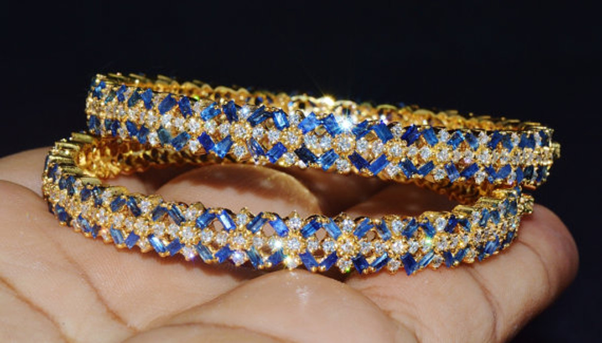 Certified natural 18K solid gold 25.21CTS diamond and sapphire bangles pair. These bangles are studded with 6.4CTS of VS F-G round brilliant cut diamonds and 18.81CTS of natural Ceylon blue sapphires.