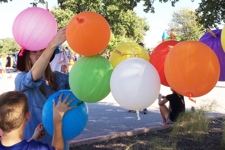 Boy choosing carnival prize at a school carnival with balloon decorations