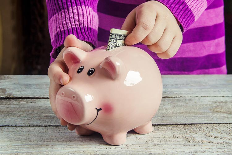 child-putting-money-in-a-piggy-bank.jpg