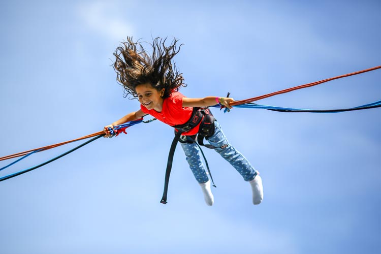 Little girl enjoying a bungee jump ride at a school carnival!