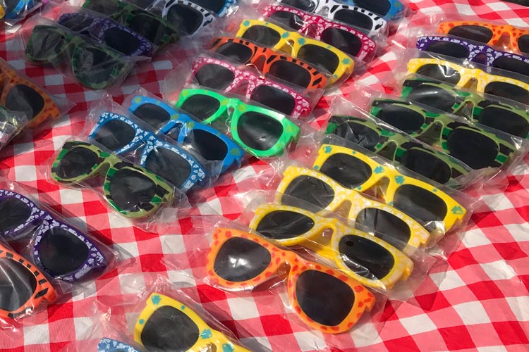 Organized sunglasses on a tablecloth at a carnival