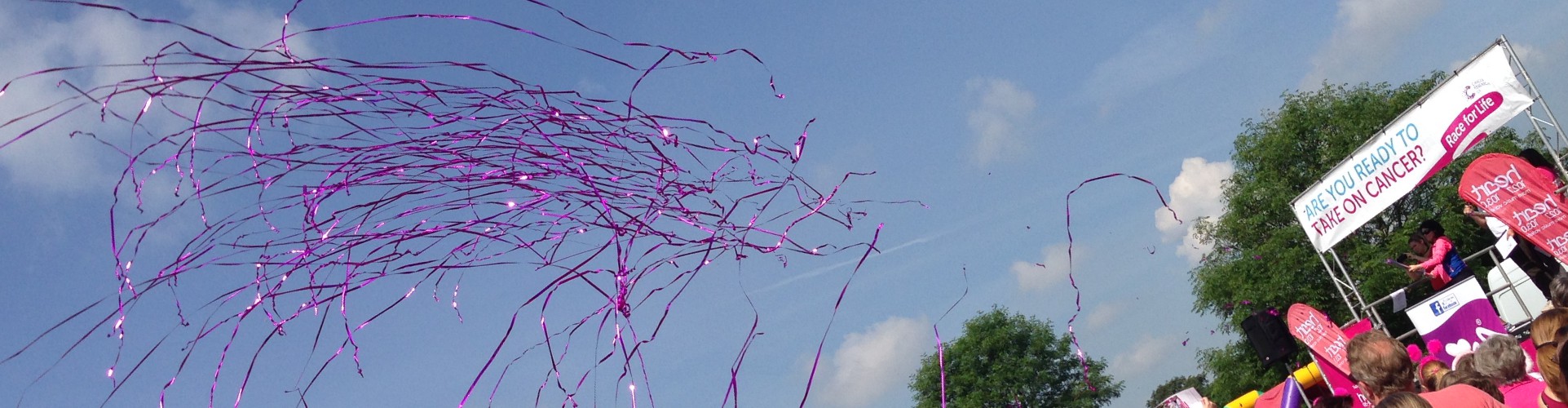 pink streamers shoot over a crowd